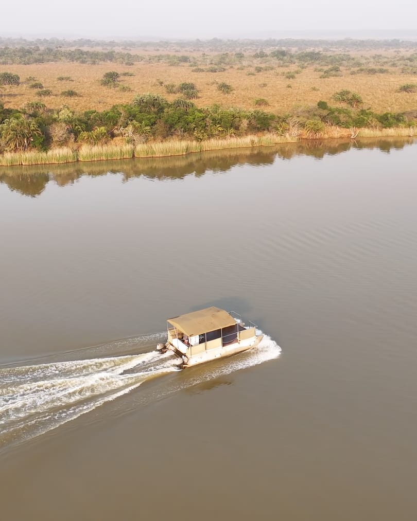 Aerial following the barge up a wide channel of the Narrows, its wake spreading across calm water