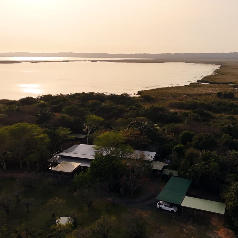First light over Lake St Lucia, the lodge roofs among the trees below.