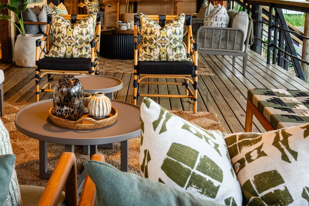 The veranda lounge along the deck with patterned sofas, artworks and a round coffee table