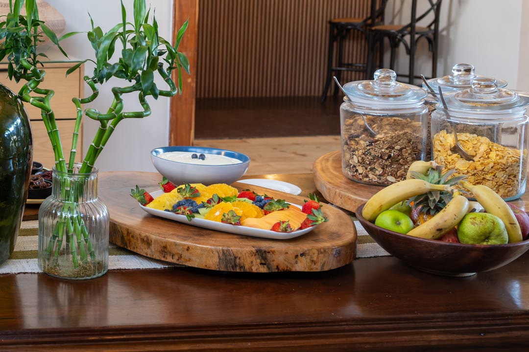 The breakfast buffet in the dining room with croissants, fruit, cheese and a buffalo painting